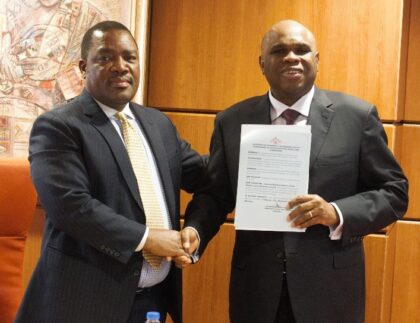 Afreximbank Prof. Benedict Oramah (right) displays the instrument of accession from Eswatini as he shakes hands with Promise Msibi, Permanent Representative of Eswatini to the African Union and Ambassador to Ethiopia, during the ceremony in Cairo.